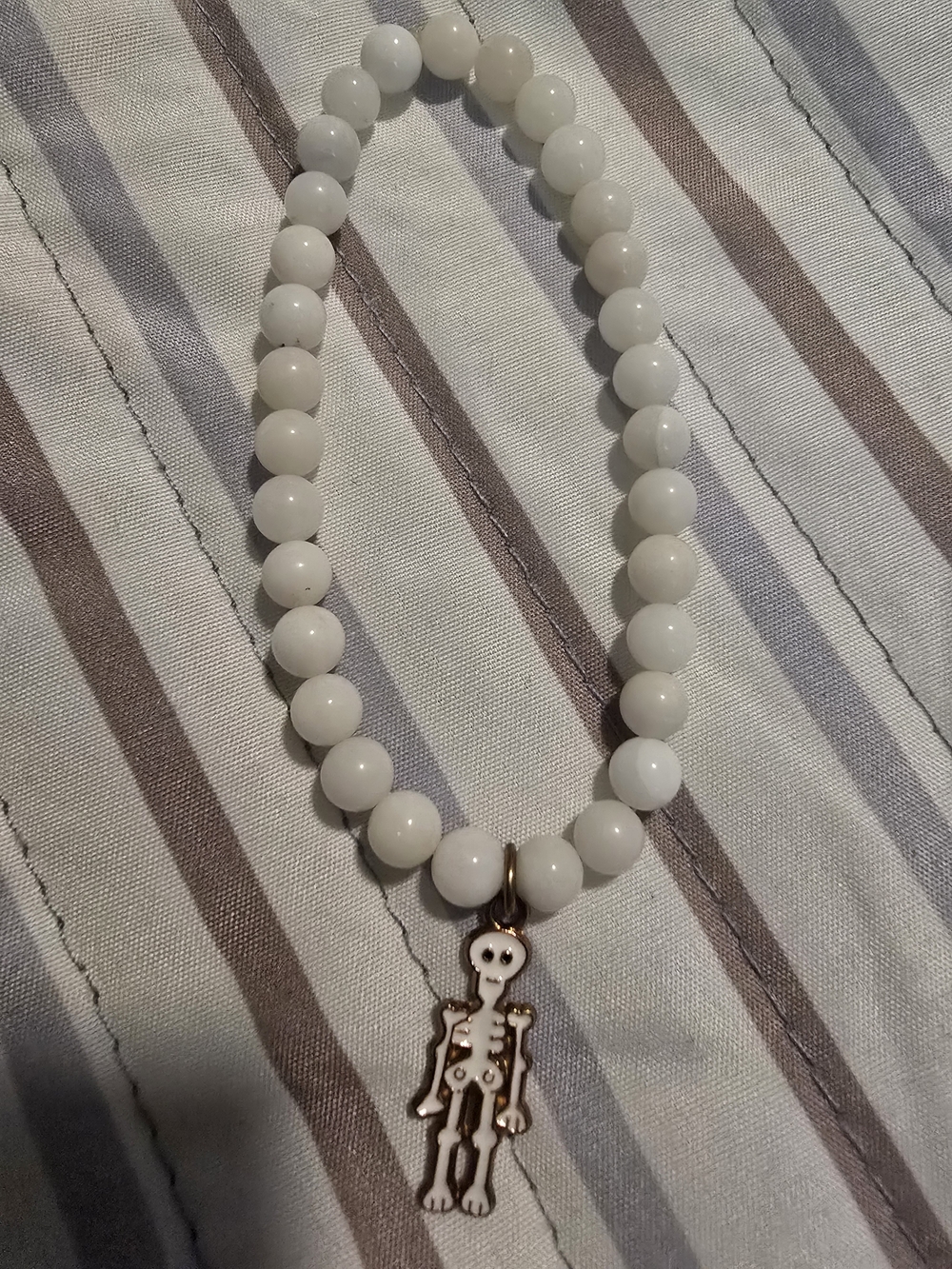 White Beaded Bracelet with Gold Skeleton Charm